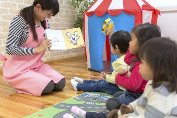 絵本を読み聞かせる保育士